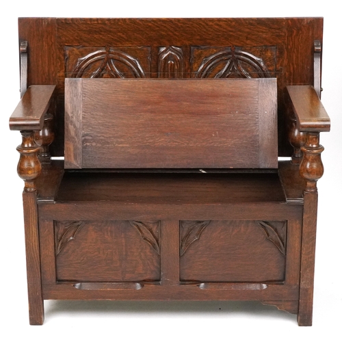  Victorian Gothic Revival oak monk's bench with carved decoration, the box seat above a panelled fron... 