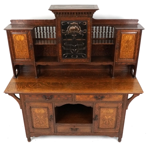  Shapland and Petter an Arts & Crafts oak sideboard with inlaid floral decoration, the dental moulded... 