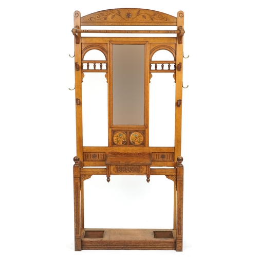  Arts & Crafts oak hall stand with carved and hand painted decoration, the mirrored back above a brus... 