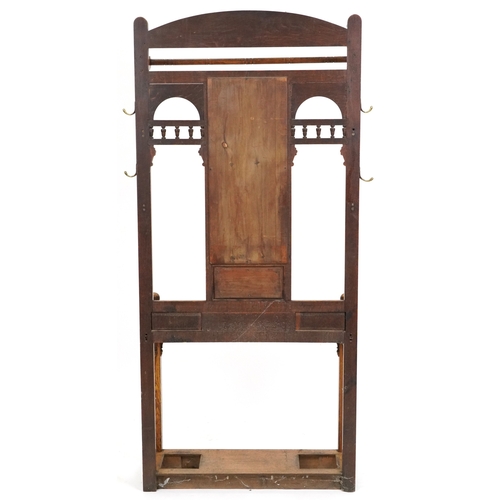  Arts & Crafts oak hall stand with carved and hand painted decoration, the mirrored back above a brus... 