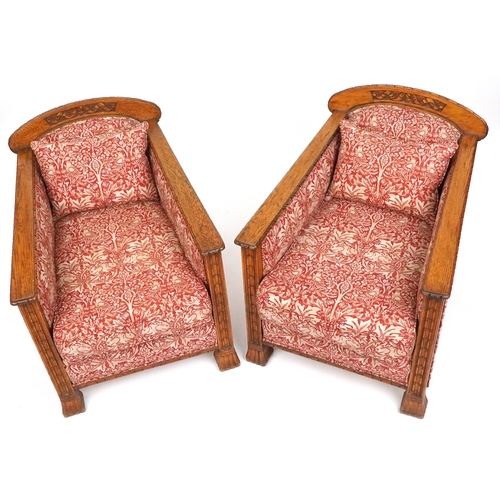  Pair of Arts & Crafts oak framed armchairs with carved decoration, upholstered in Arts & Crafts styl... 