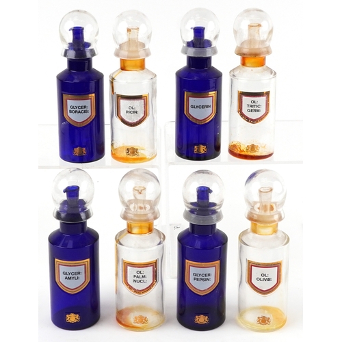 83 - Eight Royal Pharmaceutical Society coloured glass chemist bottles with domed lids, each bearing a gi... 