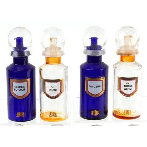 83 - Eight Royal Pharmaceutical Society coloured glass chemist bottles with domed lids, each bearing a gi... 