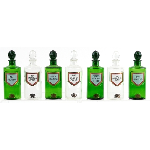 85 - A collection of Royal Pharmaceutical Society coloured glass chemist bottles with facetted stoppers, ... 