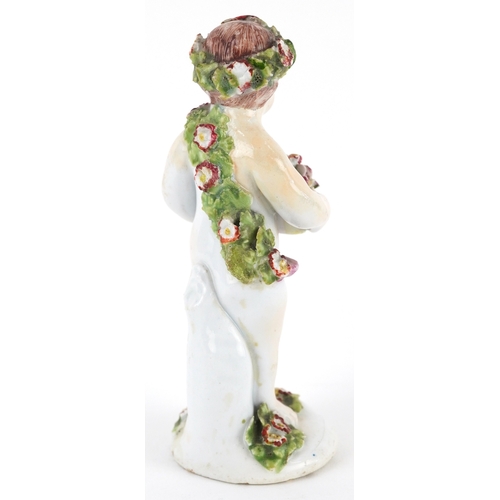 28 - A 18th century Putto encrusted with flowers, probably Derby, 11cm high.