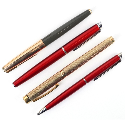 120 - A Sheaffer gold plated engine turned fountain pen with 14K gold nib, together with a Parker fountain... 