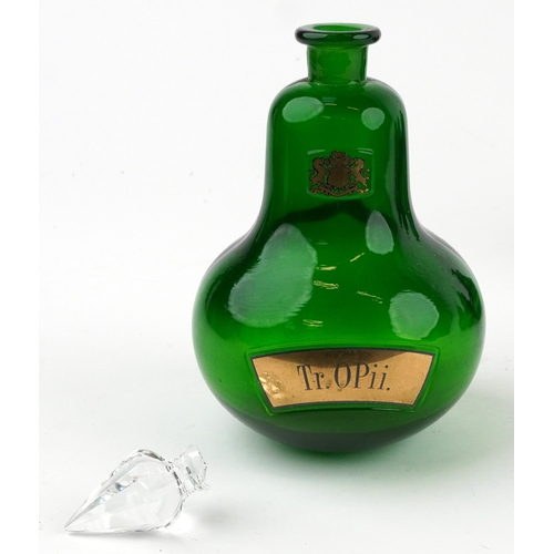 73 - A set of four Royal Pharmaceutical Society emerald glass apothecary bottles with cut glass stoppers,... 