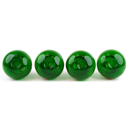 73 - A set of four Royal Pharmaceutical Society emerald glass apothecary bottles with cut glass stoppers,... 