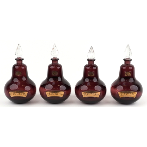 75 - A set of four Royal Pharmaceutical Society ruby glass apothecary bottles with cut glass stoppers, ea... 
