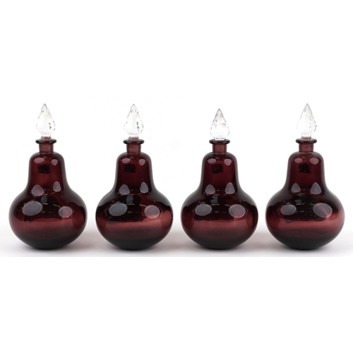 75 - A set of four Royal Pharmaceutical Society ruby glass apothecary bottles with cut glass stoppers, ea... 