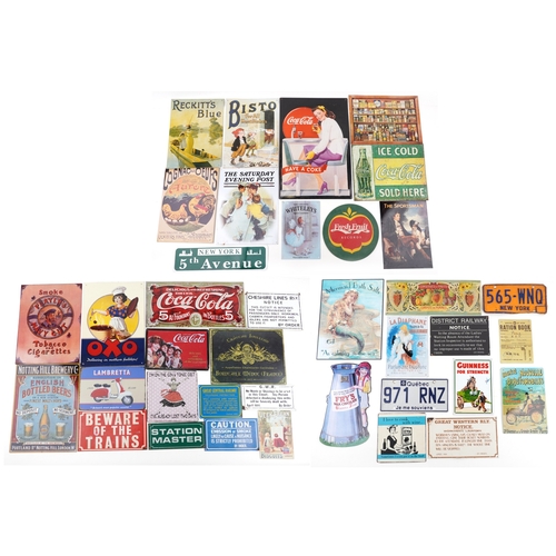 A large collection of reproduction advertising signs including Coca ...