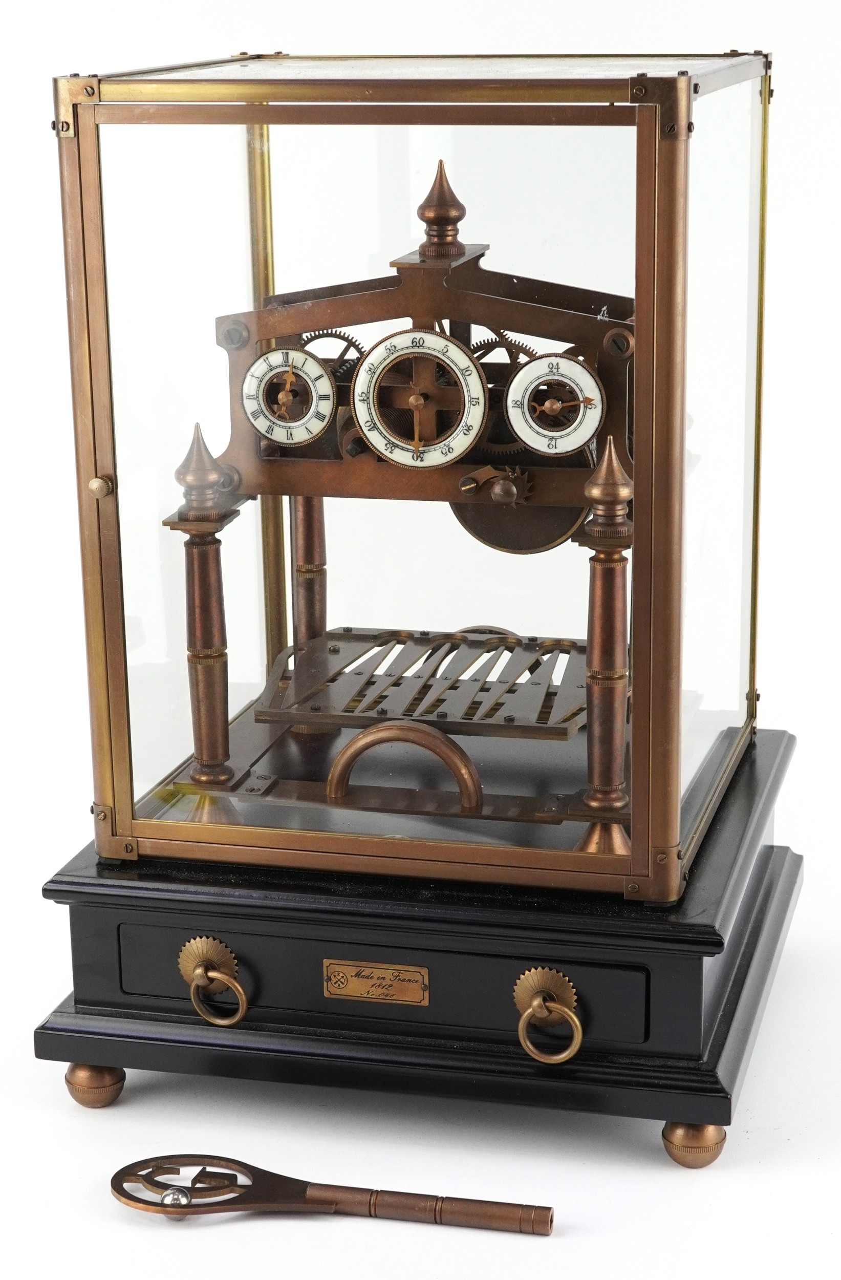 A brass Congreve style rolling ball clock with three enamelled dials ...