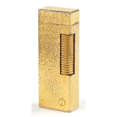100 - A Dunhill gold plated engine turned pocket lighter with guarantee card, 6.5cm high.