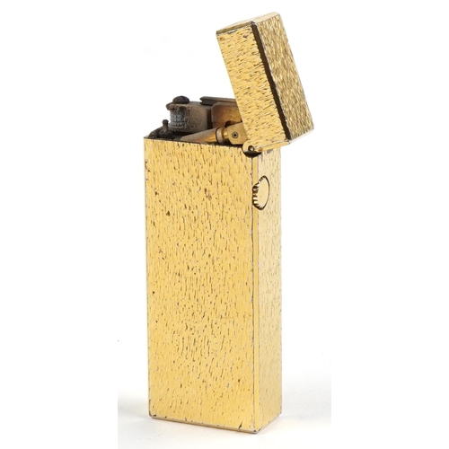 100 - A Dunhill gold plated engine turned pocket lighter with guarantee card, 6.5cm high.