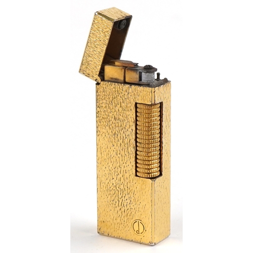 100 - A Dunhill gold plated engine turned pocket lighter with guarantee card, 6.5cm high.