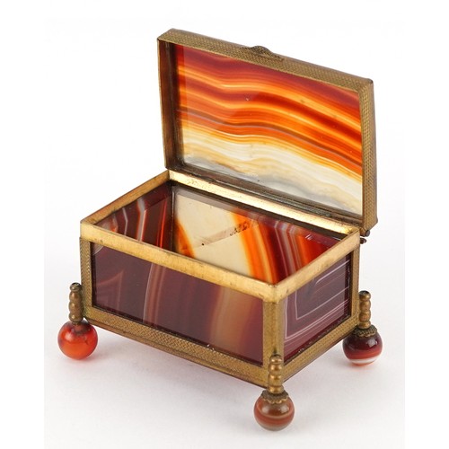 39 - An antique agate and brass jewel box raised on four ball feet, 4.5cm high x 6.5cm wide.