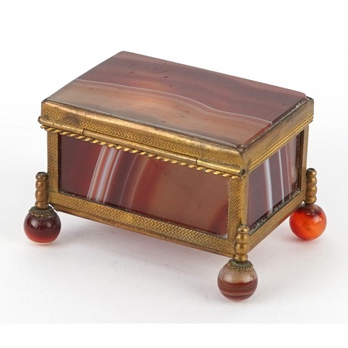 39 - An antique agate and brass jewel box raised on four ball feet, 4.5cm high x 6.5cm wide.