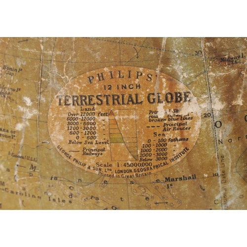  George Philip & Son twelve inch terrestrial globe raised on a cast iron tripod stand, 53cm high.