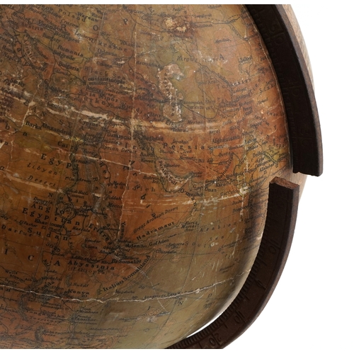  George Philip & Son twelve inch terrestrial globe raised on a cast iron tripod stand, 53cm high.