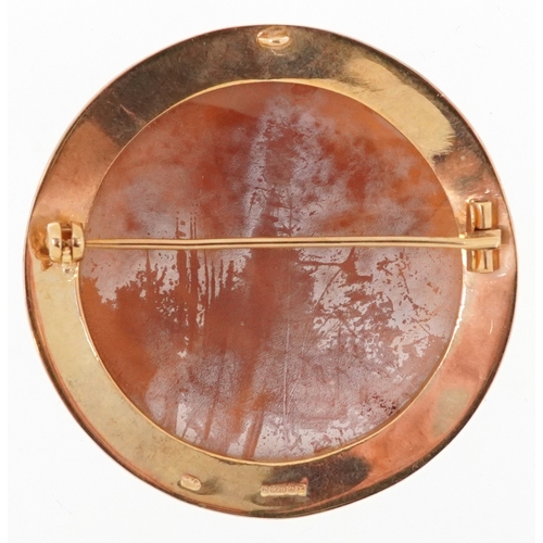  9ct gold mounted cameo shell brooch carved with flowers, 4.5cm in diameter, 12.2g.