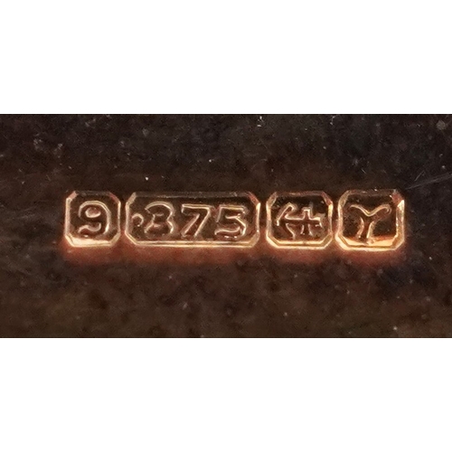  9ct gold mounted cameo shell brooch carved with flowers, 4.5cm in diameter, 12.2g.