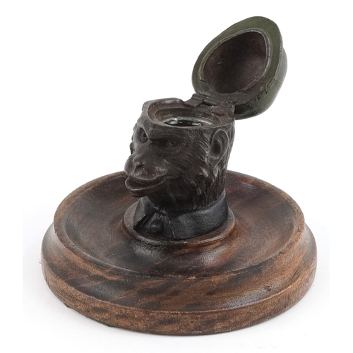 6 - Novelty cold painted inkwell in the form of a monkey, with glass liner, mounted on an oak base, 9cm ... 