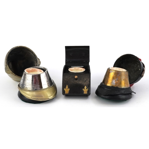 8 - Military interest inkwells, two in the form of firemen's helmets, the largest 10cm high.
