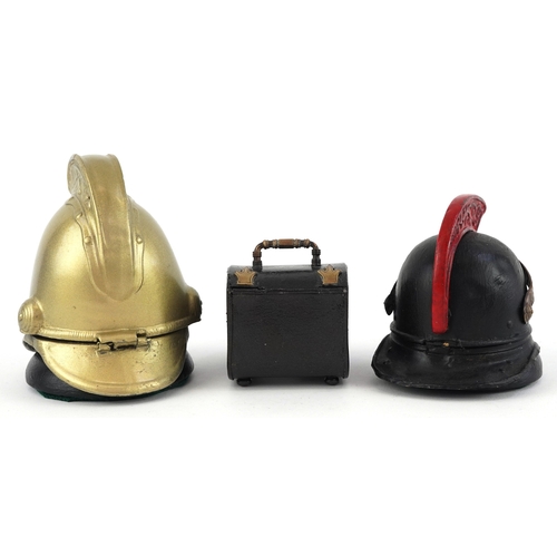8 - Military interest inkwells, two in the form of firemen's helmets, the largest 10cm high.
