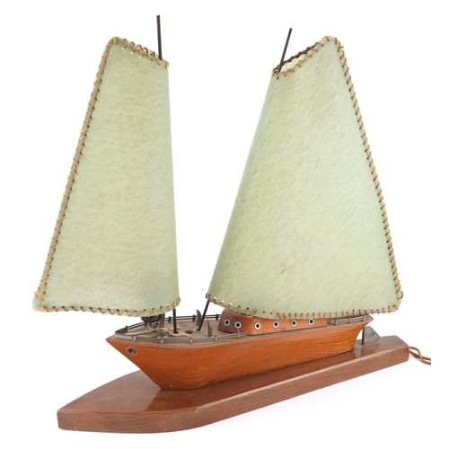 Mid century teak table lamp in the form of a sailing boat, 42cm in length.