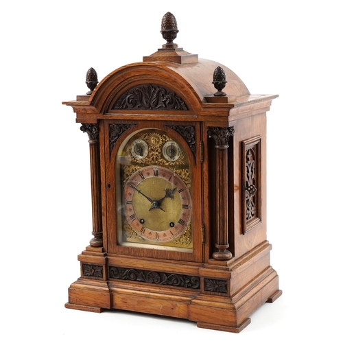 Victorian oak cased bracket clock having brass face and silvered dial with Roman numerals, striking on a gong, the case with Corinthian column supports and acorn finials, 58cm high.