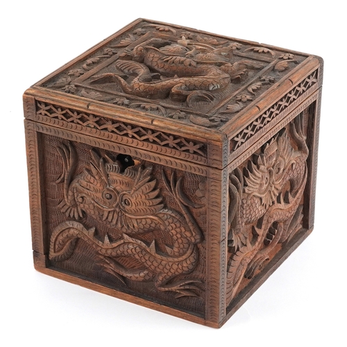 Chinese softwood box having a hinged lid carved with dragons, 13.5cm H x 14.5cm W x 14.5cm D.