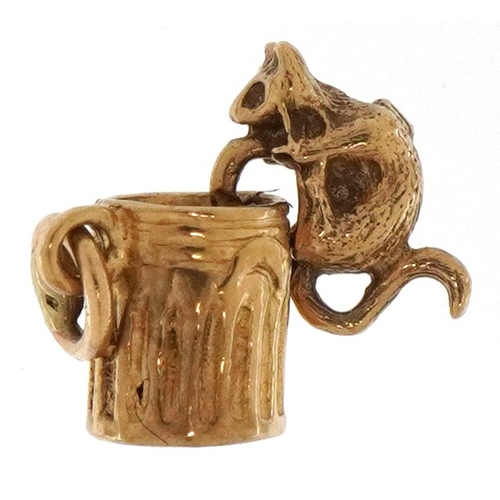 3299 - 9ct gold articulated charm in the form of a cat in a can, 1.2cm high, 1.2g.