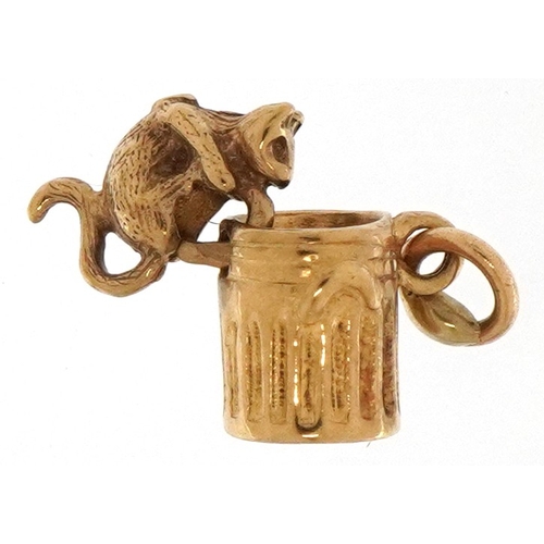 3299 - 9ct gold articulated charm in the form of a cat in a can, 1.2cm high, 1.2g.