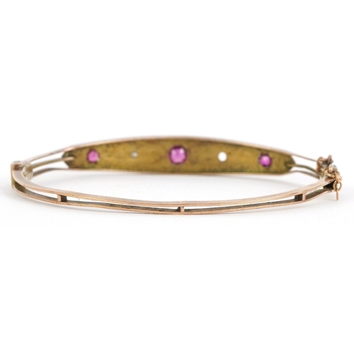3042 - Edwardian 9ct gold ruby and diamond bangle, 6cm wide, 7.8g.