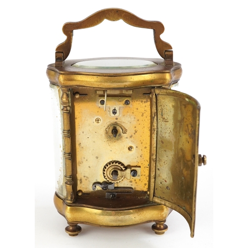 76 - Gilt brass serpentine glass carriage clock having enamelled dial with Roman numerals, 13cm high.