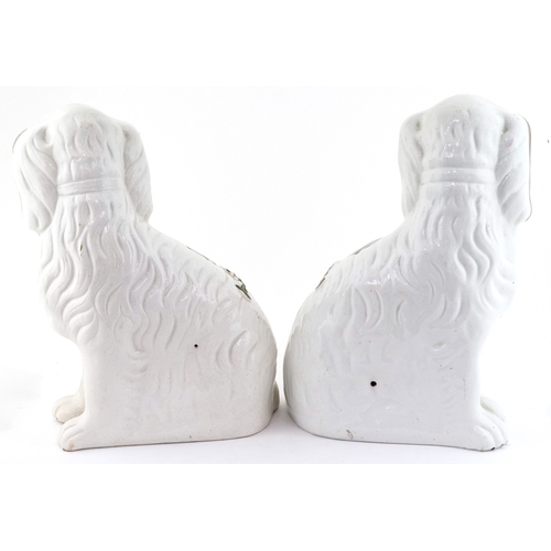 229 - Pair of Staffordshire style seated Spaniels with hand painted decoration, 22.5cm high.