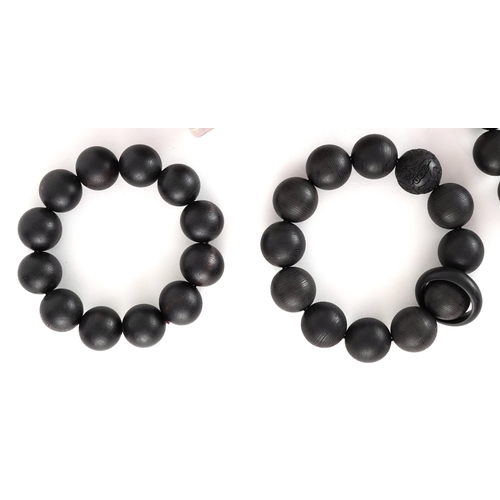 Four Chinese carved wooden bead bracelets, two with Chinese coin motifs ...