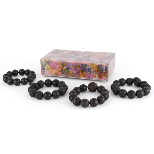 Four Chinese carved wooden bead bracelets, two with Chinese coin motifs ...