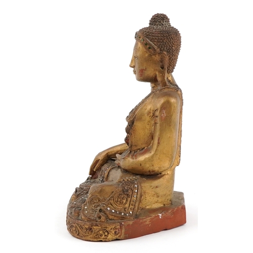  Burmese carved wood seated Buddha decorated with green and clear glass inlay, 34.5cm high.