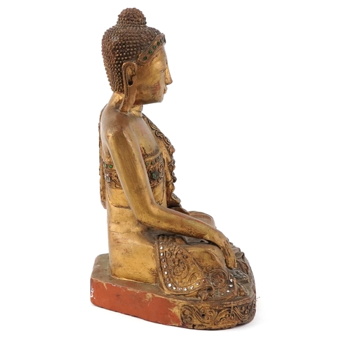  Burmese carved wood seated Buddha decorated with green and clear glass inlay, 34.5cm high.