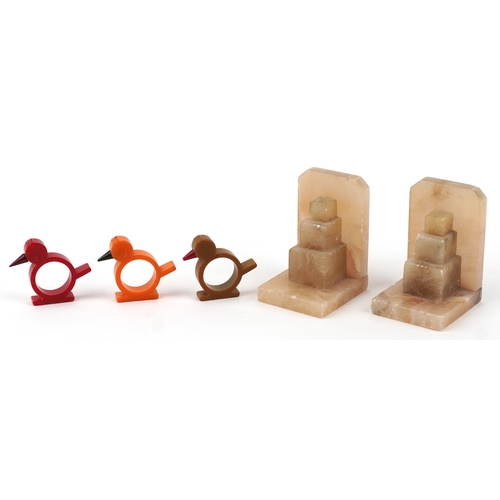  Three Art Deco Bakelite napkin rings in the form of birds and a pair of Art Deco onyx bookends, the ... 