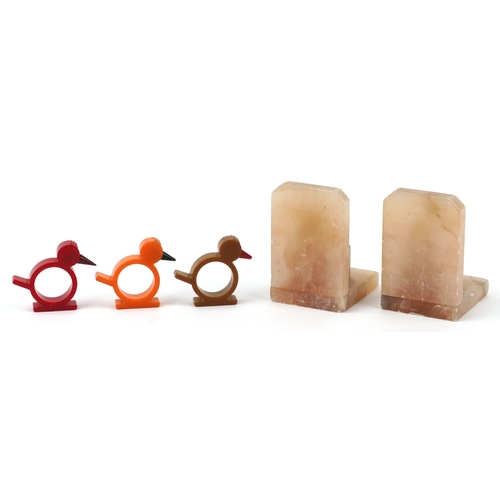  Three Art Deco Bakelite napkin rings in the form of birds and a pair of Art Deco onyx bookends, the ... 
