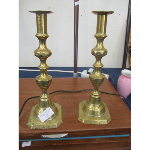 83 - A PAIR OF BRASS CANDLE STICKS