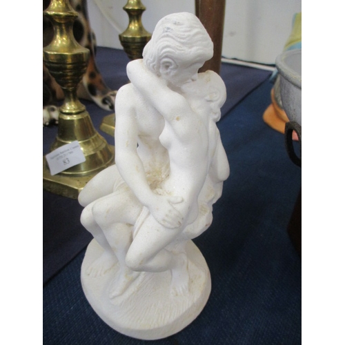 84 - A WHITE FIGURINE OF A  YOUNG COUPLE KISSING