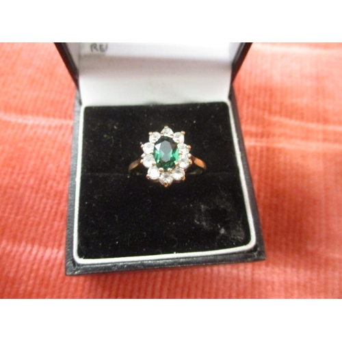 27 - 9CT GOLD RING WITH A GREEN CENTRE STONE SURROUNDED BY CLEAR STONES, SIZE L