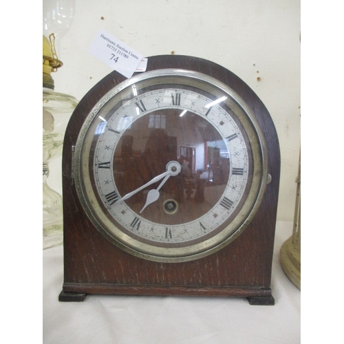 74 - A VINTAGE ARCH TOP MANTLE CLOCK IN OAK CASING WITH PENDULUM AND KEY