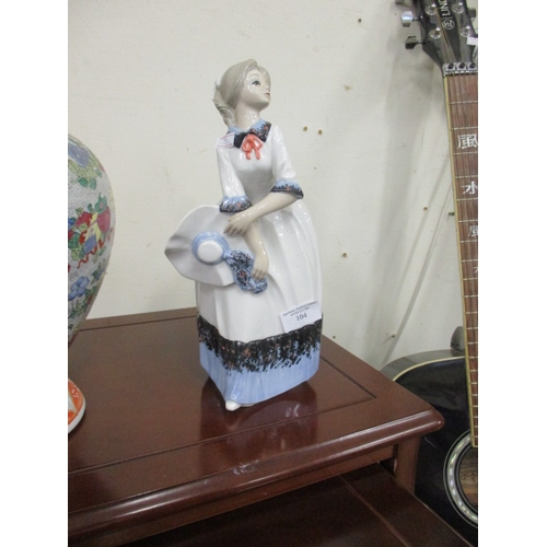 104 - A PORCELAIN FIGURINE OF A LADY