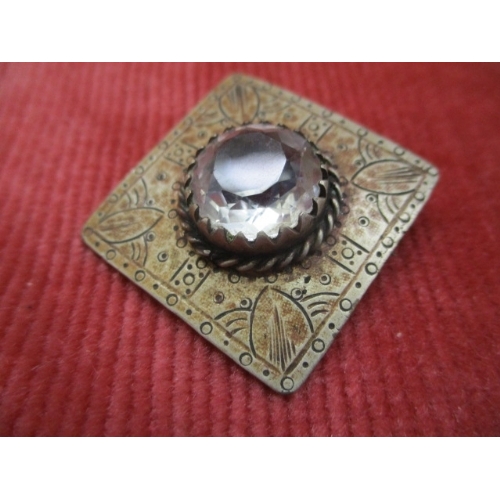 16 - A SILVER COLOURED BROOCH WITH LARGE WHITE STONE TO THE CENTRE