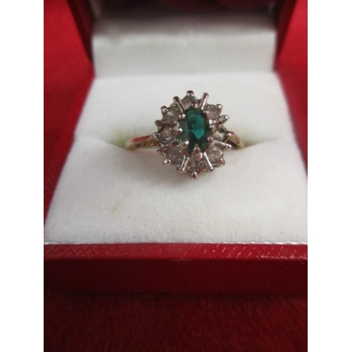 1 - GOLD DRESS RING INSET WITH AN GREEN STONE SURROUNDED IN CLEAR STONES