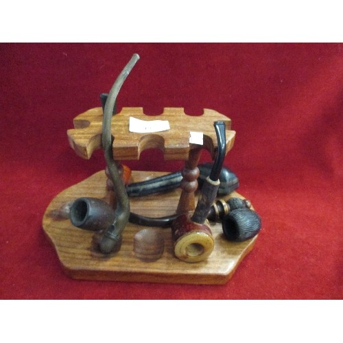 19 - COLLECTION OF PIPES WITH A WOODEN PIPE STAND - INCLUDES PIPE WITH AMBER MOUTH PIECE IN A FITTED CASE